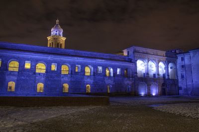 Illuminated building against sky at night