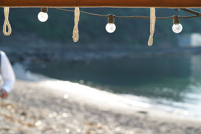 Close-up of hanging water at beach against sky