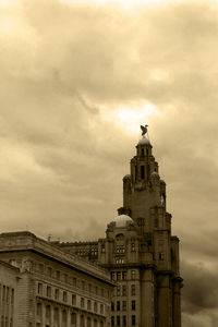 Low angle view of bell tower against cloudy sky