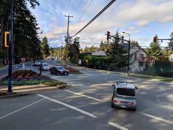 Cars on road in city against sky