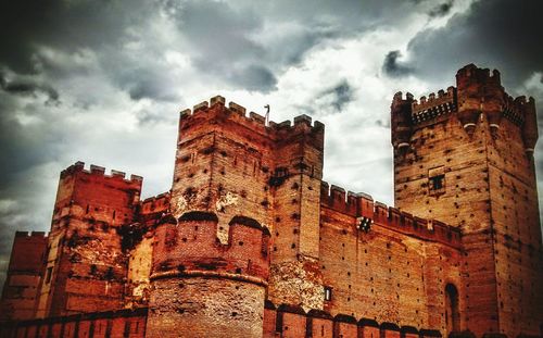 Low angle view of building against cloudy sky