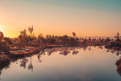Scenic view of lake against sky at sunset