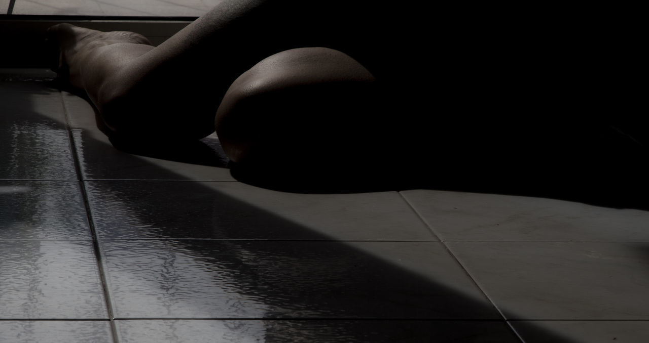 LOW SECTION OF WOMAN SITTING ON FLOORING