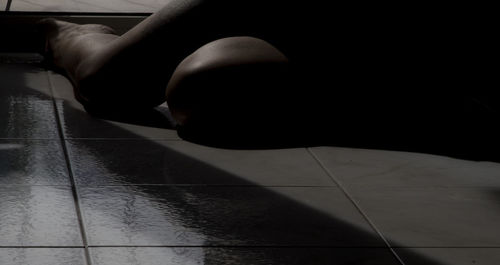 Low section of woman sitting on tiled floor