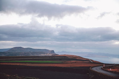 Road by mountain against sky