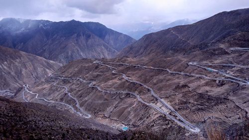 Scenic view of mountain range against cloudy sky