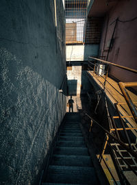 High angle view of steps amidst buildings with shadow of a man