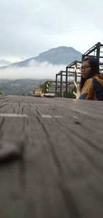 Woman on railing against sky