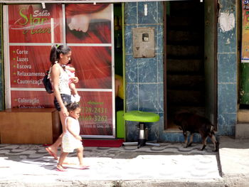 Side view of girl with dog standing outdoors