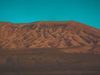 Scenic view of desert against clear blue sky