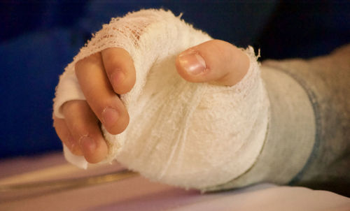 Cropped hand with bandages at table in hospital