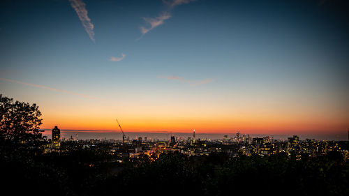 High angle view of silhouette buildings against sky during sunset