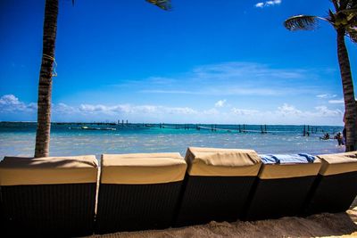 Chairs on beach against sky