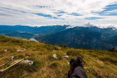 Low section of person on mountain against sky