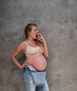 Full length of woman standing against wall