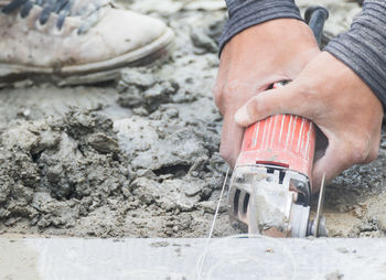 Cropped hands of man working on messy land