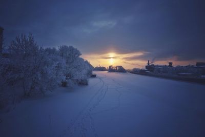 Snow covered landscape at sunset