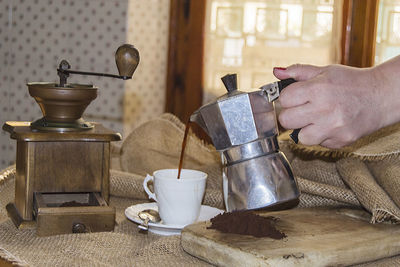 Man holding coffee cup on table