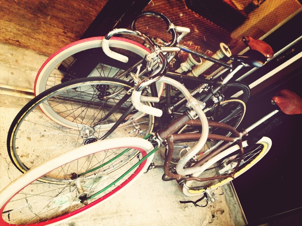 bicycle, transportation, land vehicle, stationary, indoors, high angle view, mode of transport, wheel, old, parking, old-fashioned, metal, no people, equipment, parked, still life, wall - building feature, absence, motorcycle