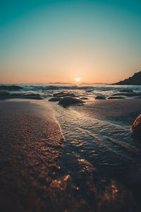 Scenic view of sea against clear sky during sunset