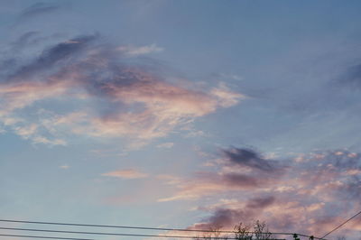 Low angle view of factory against sky during sunset
