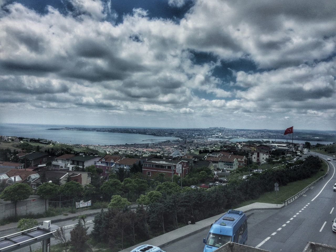 car, sky, cloud - sky, transportation, road, architecture, built structure, sea, building exterior, high angle view, land vehicle, day, water, horizon over water, no people, outdoors, city, cityscape, nature, tree, beauty in nature