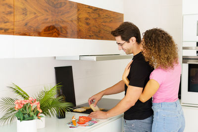 Rear view of woman with arms raised in bathroom