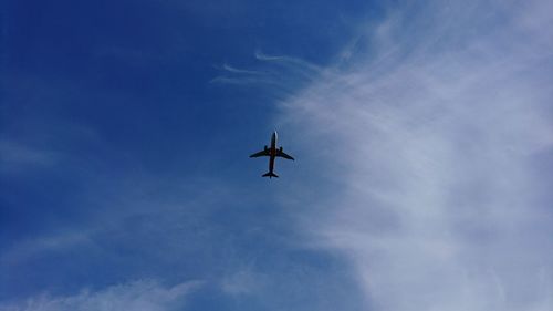 Low angle view of airplane against blue sky