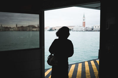 Rear view of woman standing on riverbank