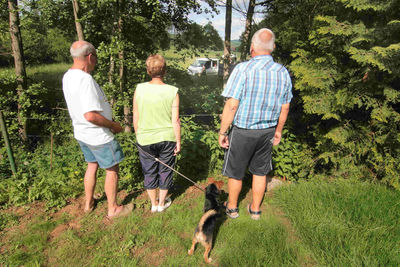 Rear view of people with dog on plants