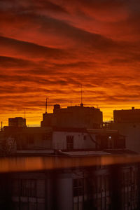 Silhouette buildings against sky during sunset