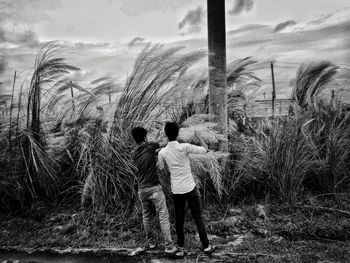 Rear view of men standing against sky