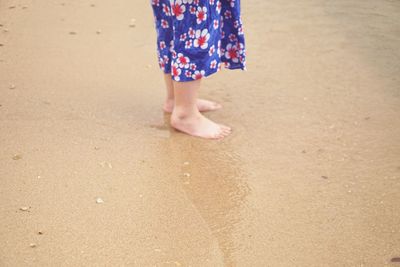 Barefooted woman standing on beach