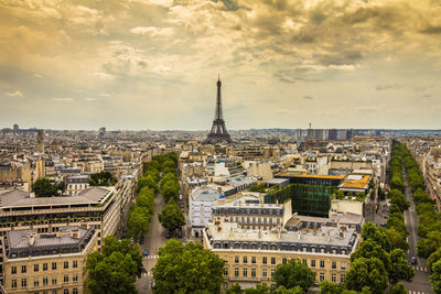 Eiffel tower amidst buildings in city against sky during sunset