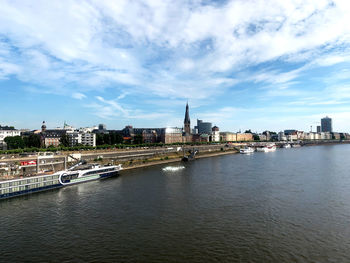Buildings by river against sky
