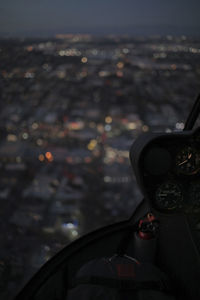Illuminated cityscape seen through helicopter's windshield at night