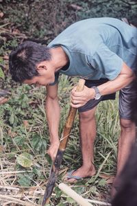 Mid adult man cleaning stick outdoors