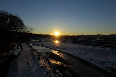 Snow covered road at sunset