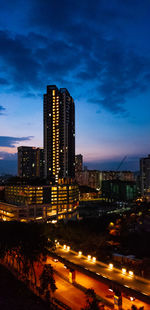 Illuminated modern buildings against sky at night