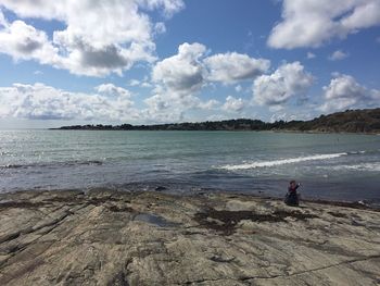 Woman standing on beach against sky