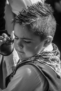 Close-up portrait of boy holding camera