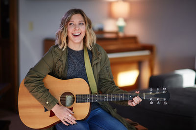 Portrait of a smiling young man playing guitar