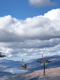 Airplane flying over mountains against sky