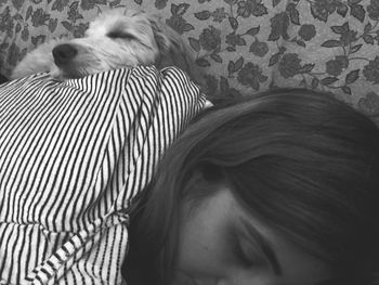 Close-up of dog and woman resting at home