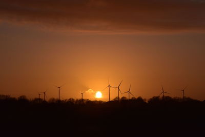 Silhouette of wind turbines at sunset