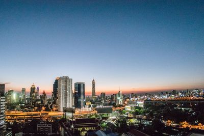 Illuminated city against clear sky