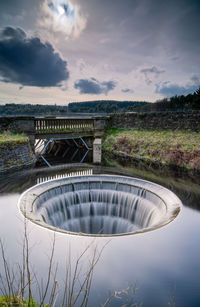 View of dam overflow against a sky. 