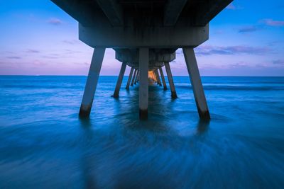 Pier on sea against sky during sunset