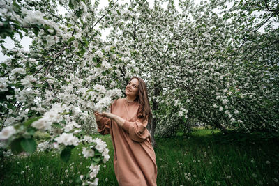 Beautiful young girl in the garden of blooming apple trees