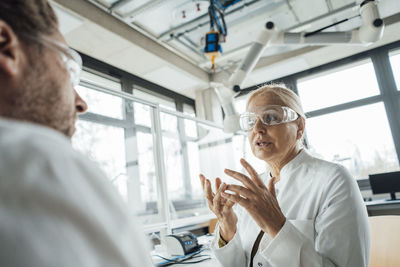 Senior scientist explaining to colleague in laboratory